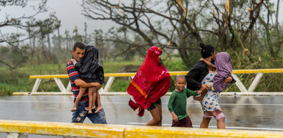 Una familia camina en la lluvia tras huracán Ian golpear a Pinar del Río Cuba septiembre de 2022